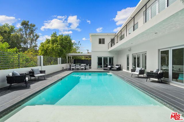 a view of a house with swimming pool and sitting area