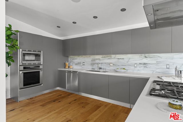 a kitchen with stainless steel appliances a stove a sink and a refrigerator