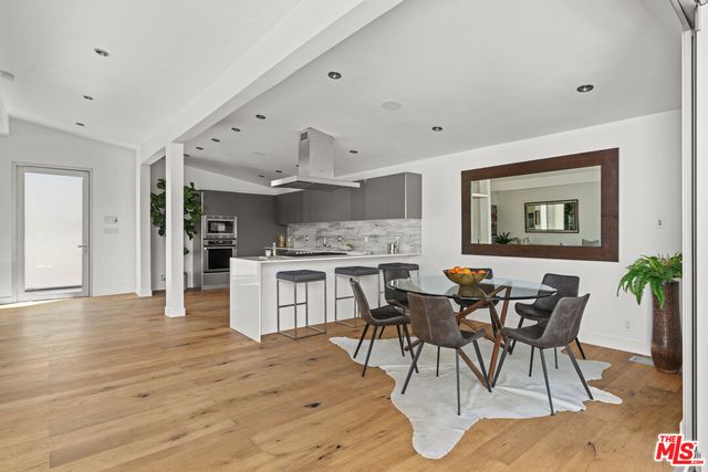 a open kitchen with stainless steel appliances kitchen island granite countertop a table and chairs in it