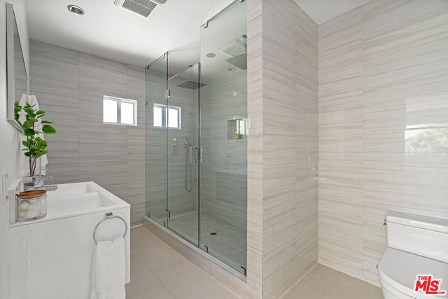 a bathroom with a shower a mirror and a sink