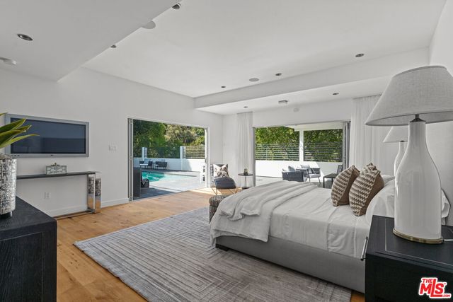 a bedroom with a bed and a large window