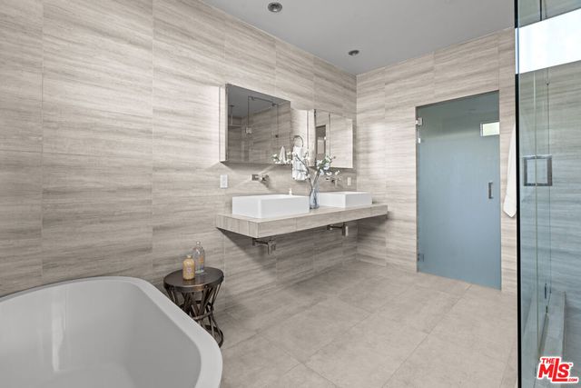 a bathroom with a tub sink and mirror