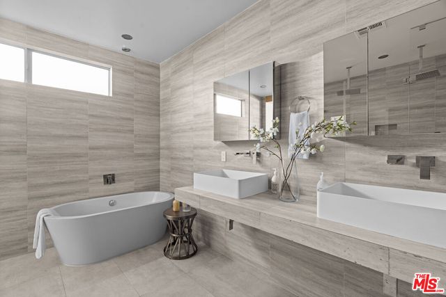 a bathroom with a white tub a vanity a sink and a bathtub