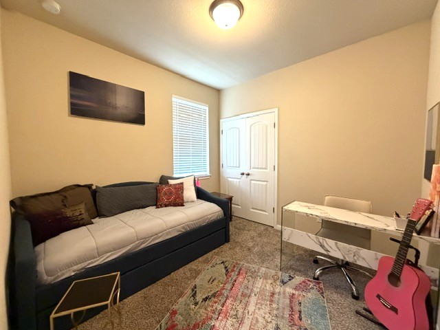 413 Anacua Loop, Unit 8 Manchaca, TX 78652 - Photo 17 of 23 Plush carpeting and a classic double-door closet anchor this versatile guest space.