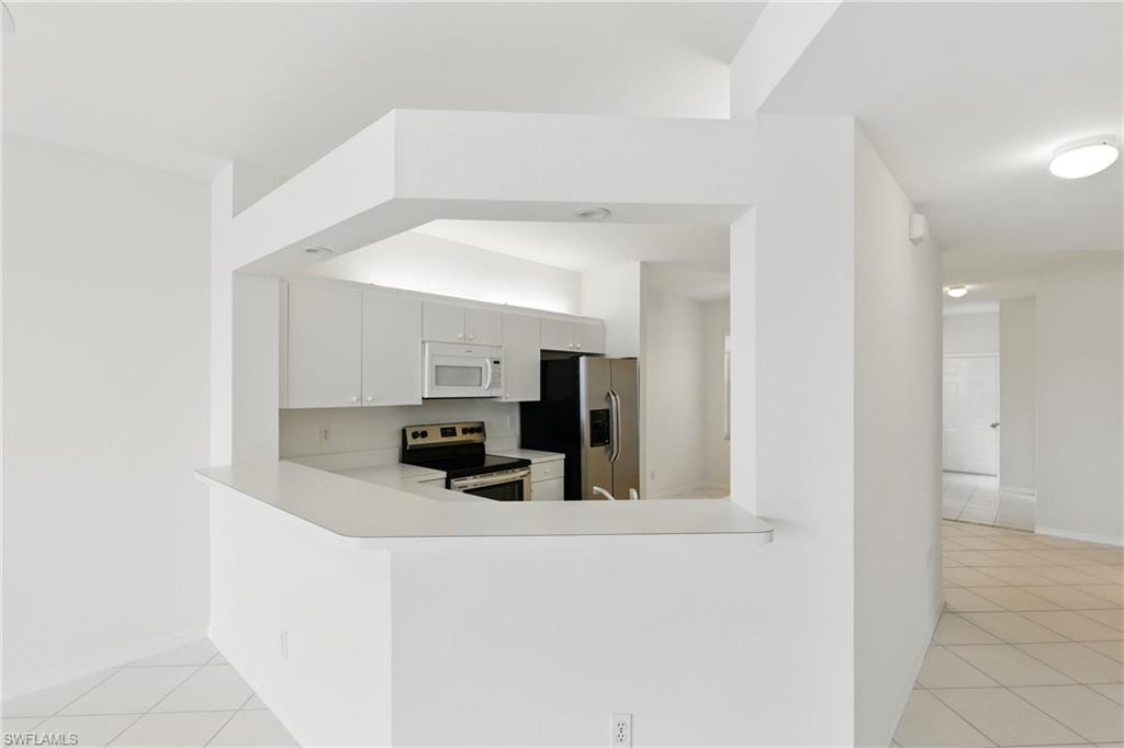 3460 West Crown Pointe Boulevard, Unit 101 Naples, FL 34112 - Photo 13 of 43 a view of a kitchen with electric appliances