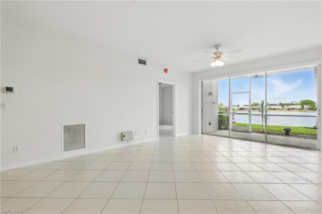 3460 West Crown Pointe Boulevard, Unit 101 Naples, FL 34112 - Photo 16 of 43 a view of an empty room with glass door and chandelier fan
