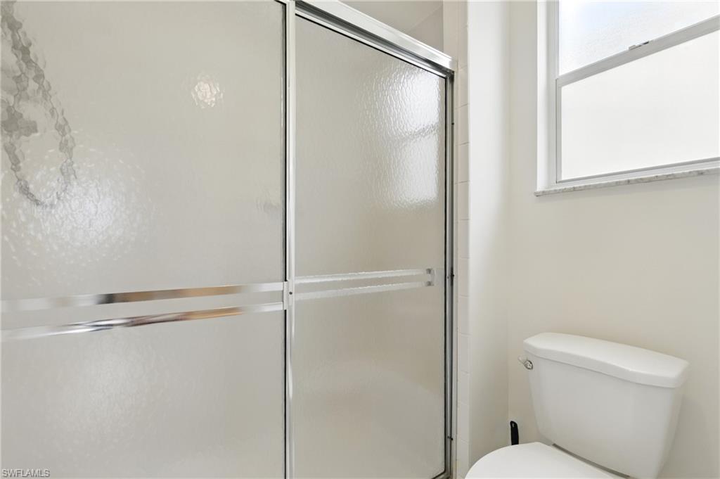 3460 West Crown Pointe Boulevard, Unit 101 Naples, FL 34112 - Photo 22 of 43 a bathroom with a shower and a toilet