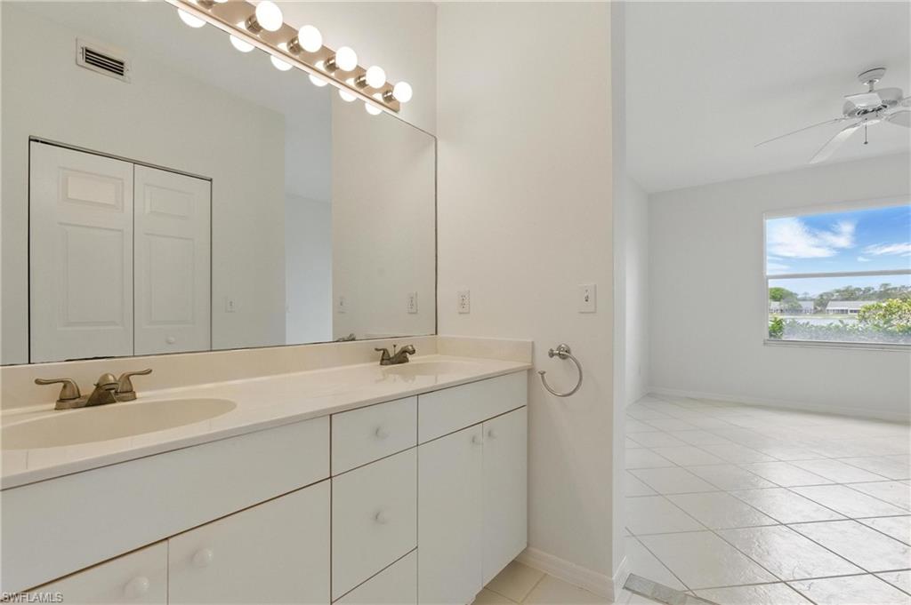 3460 West Crown Pointe Boulevard, Unit 101 Naples, FL 34112 - Photo 23 of 43 a bathroom with a double vanity sink and a mirror