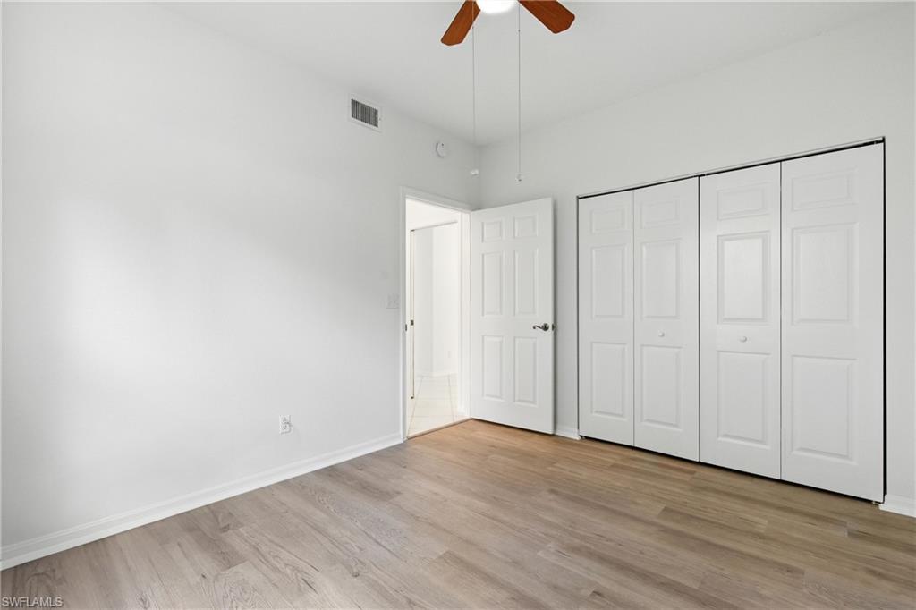 3460 West Crown Pointe Boulevard, Unit 101 Naples, FL 34112 - Photo 26 of 43 a view of an empty room with wooden floor