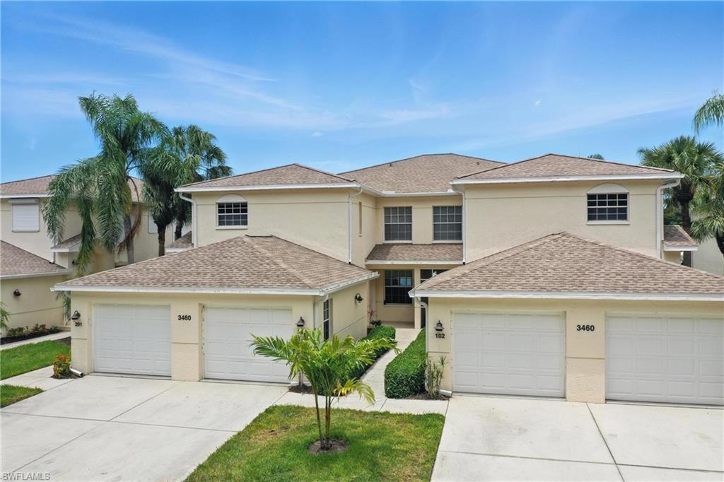 3460 West Crown Pointe Boulevard, Unit 101 Naples, FL 34112 - Photo 3 of 43 a front view of a house with a garden and plants