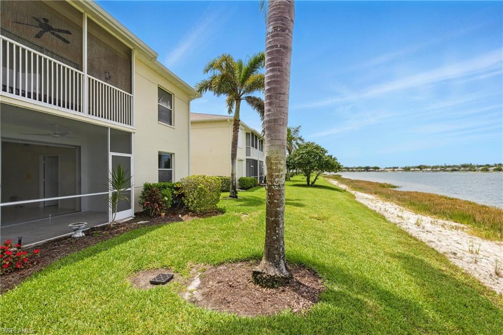 3460 West Crown Pointe Boulevard, Unit 101 Naples, FL 34112 - Photo 32 of 43 a front view of a house with a yard