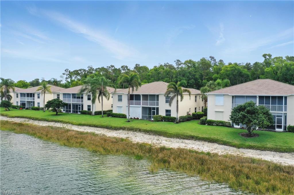 3460 West Crown Pointe Boulevard, Unit 101 Naples, FL 34112 - Photo 36 of 43 a front view of a house with a yard and lake view
