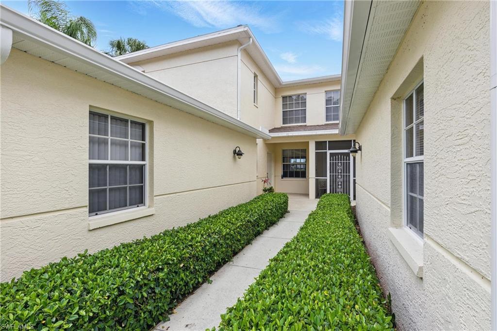 3460 West Crown Pointe Boulevard, Unit 101 Naples, FL 34112 - Photo 5 of 43 a view of a house with a yard and flower plants