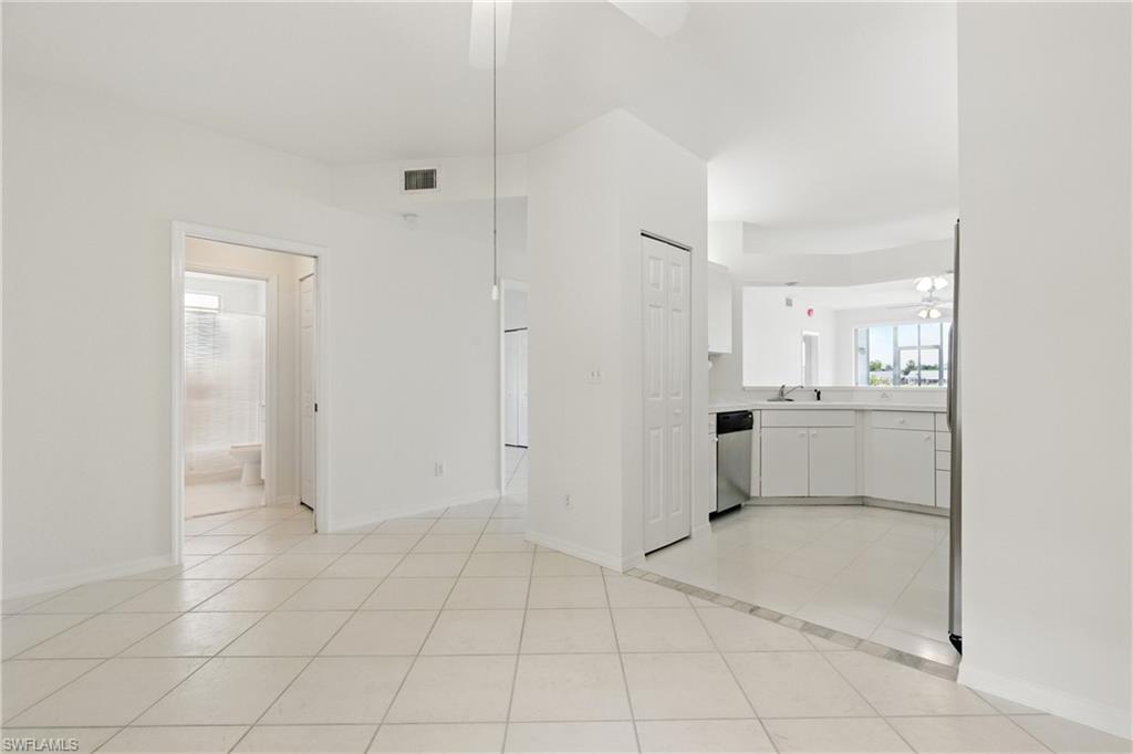 3460 West Crown Pointe Boulevard, Unit 101 Naples, FL 34112 - Photo 7 of 43 a view of a kitchen with white cabinets