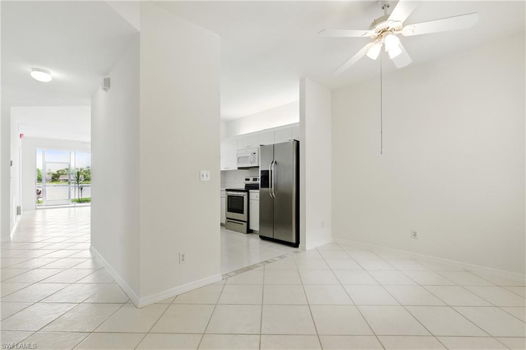 3460 West Crown Pointe Boulevard, Unit 101 Naples, FL 34112 - Photo 8 of 43 a view of a kitchen with a sink and a refrigerator
