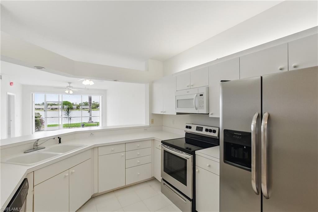 3460 West Crown Pointe Boulevard, Unit 101 Naples, FL 34112 - Photo 9 of 43 a kitchen with a refrigerator sink and stove