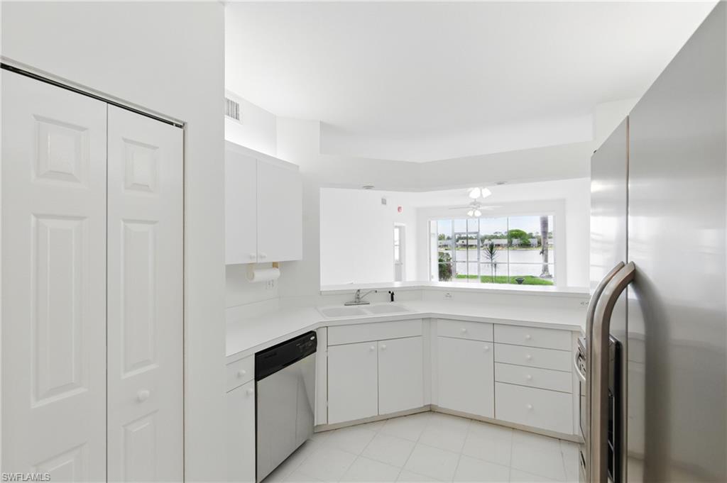 3460 West Crown Pointe Boulevard, Unit 101 Naples, FL 34112 - Photo 10 of 43 a kitchen with white cabinets and white appliances