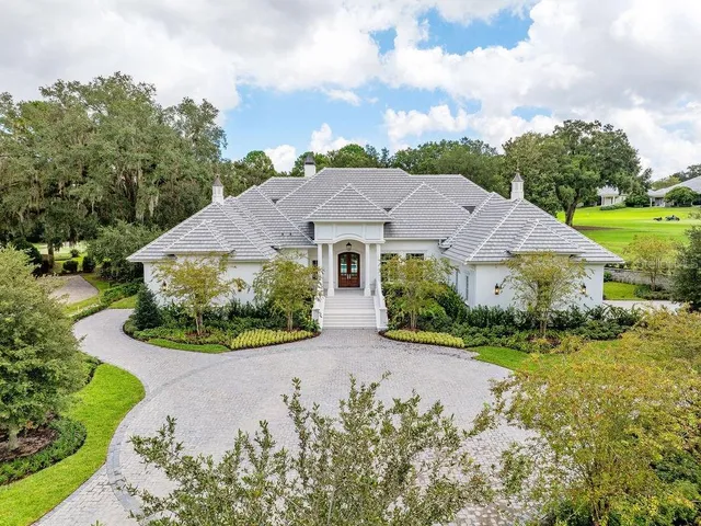 an aerial view of a house with yard and green space