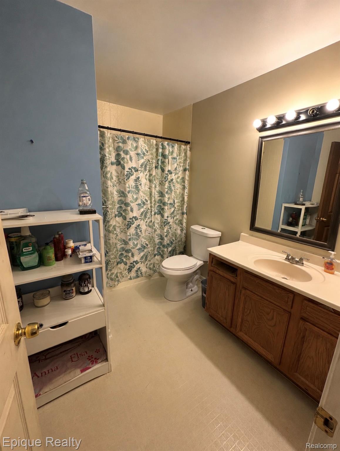 11619 Read Avenue Mount Morris, MI 48458 - Photo 4 of 10 Bathroom featuring a light-colored flooring, a white vanity with a built-in sink, and a framed mirror with vanity lighting