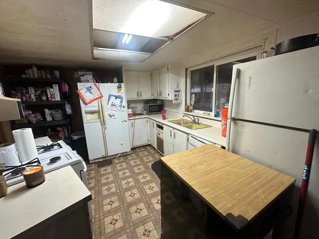 a kitchen with a refrigerator a stove and a dining table