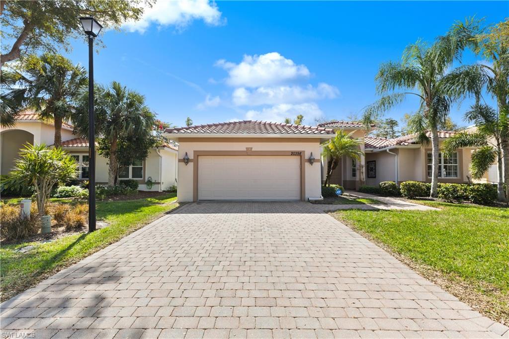 a view of a house with a yard and palm trees