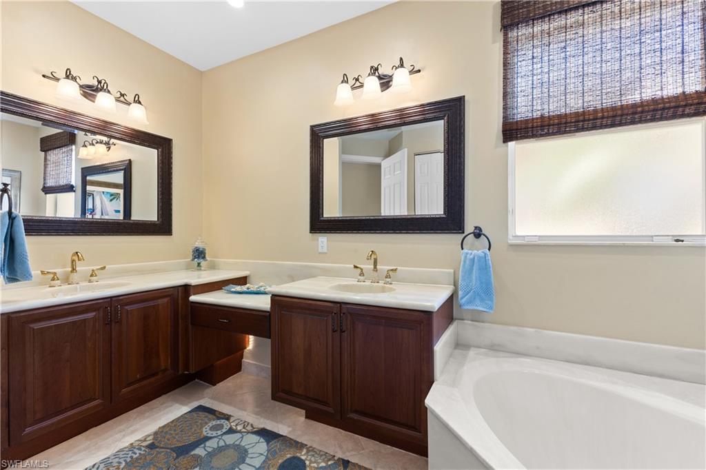 20398 Foxworth Circle Estero, FL 33928 - Photo 15 of 50 a bathroom with a tub sink and mirror