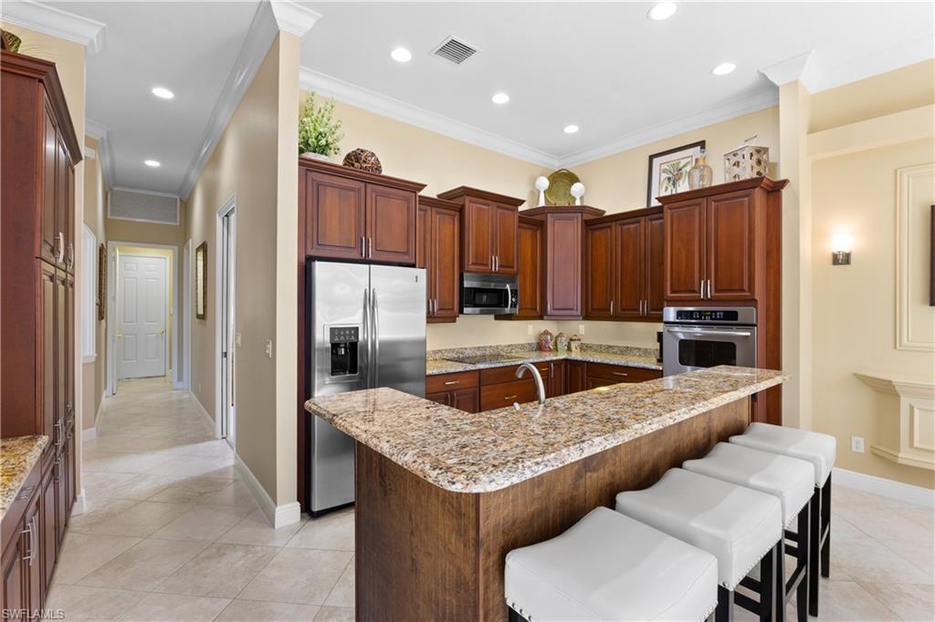 20398 Foxworth Circle Estero, FL 33928 - Photo 31 of 50 a kitchen with a table chairs refrigerator and microwave