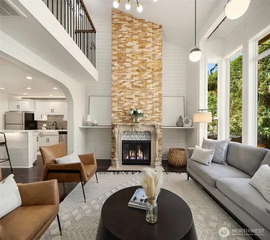 a living room with furniture fireplace and a large window