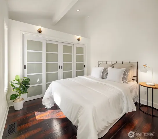 a large bed sitting in a bedroom next to a window and a potted plant