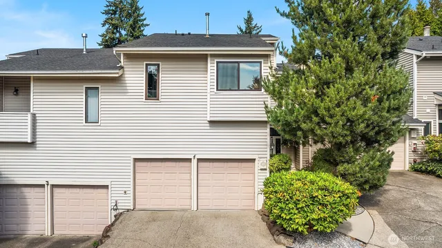 a white house with a small yard and a garage
