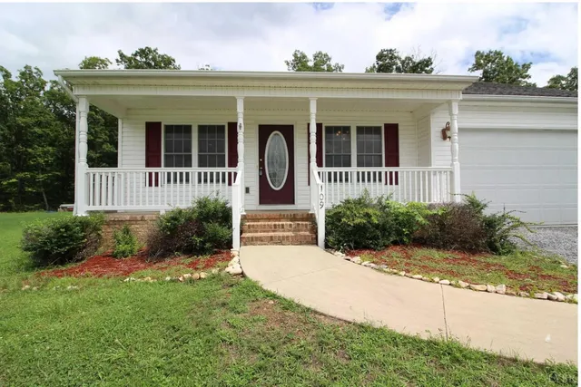 a view of a house with potted plants and a table and chairs