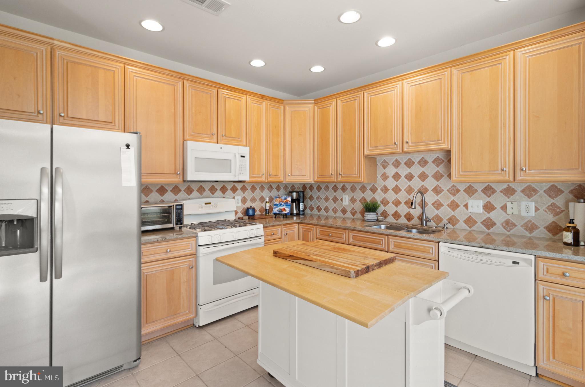 5652 Wheelwright Way Haymarket, VA 20169 - Photo 2 of 32 a kitchen with granite countertop white cabinets and refrigerator