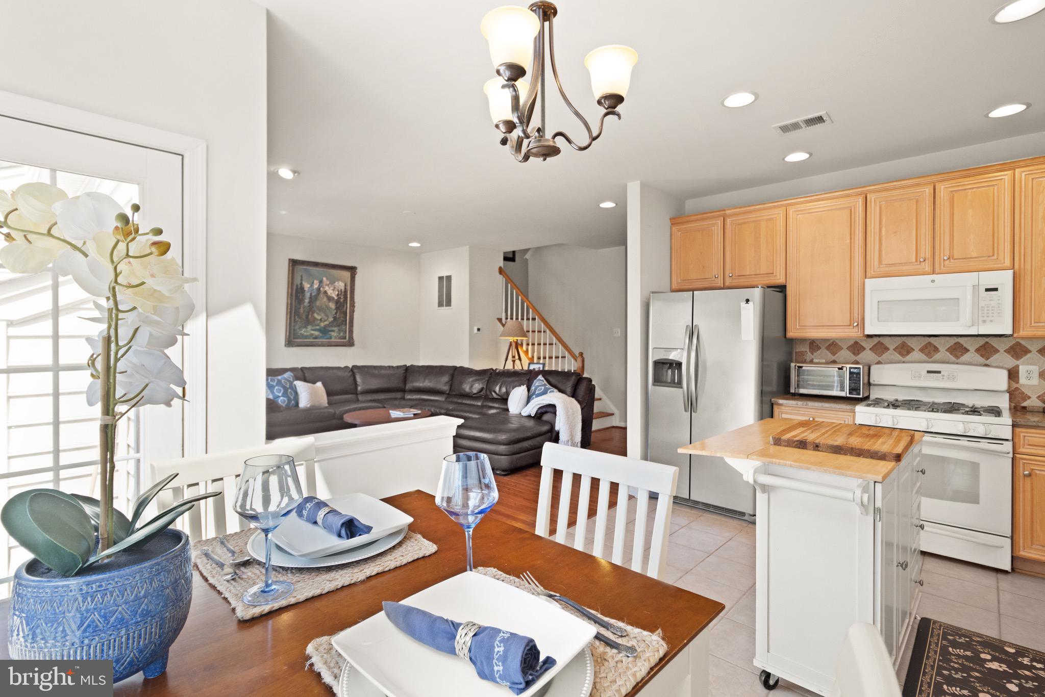 5652 Wheelwright Way Haymarket, VA 20169 - Photo 4 of 32 a kitchen with stainless steel appliances kitchen island granite countertop a table chairs in it and a window