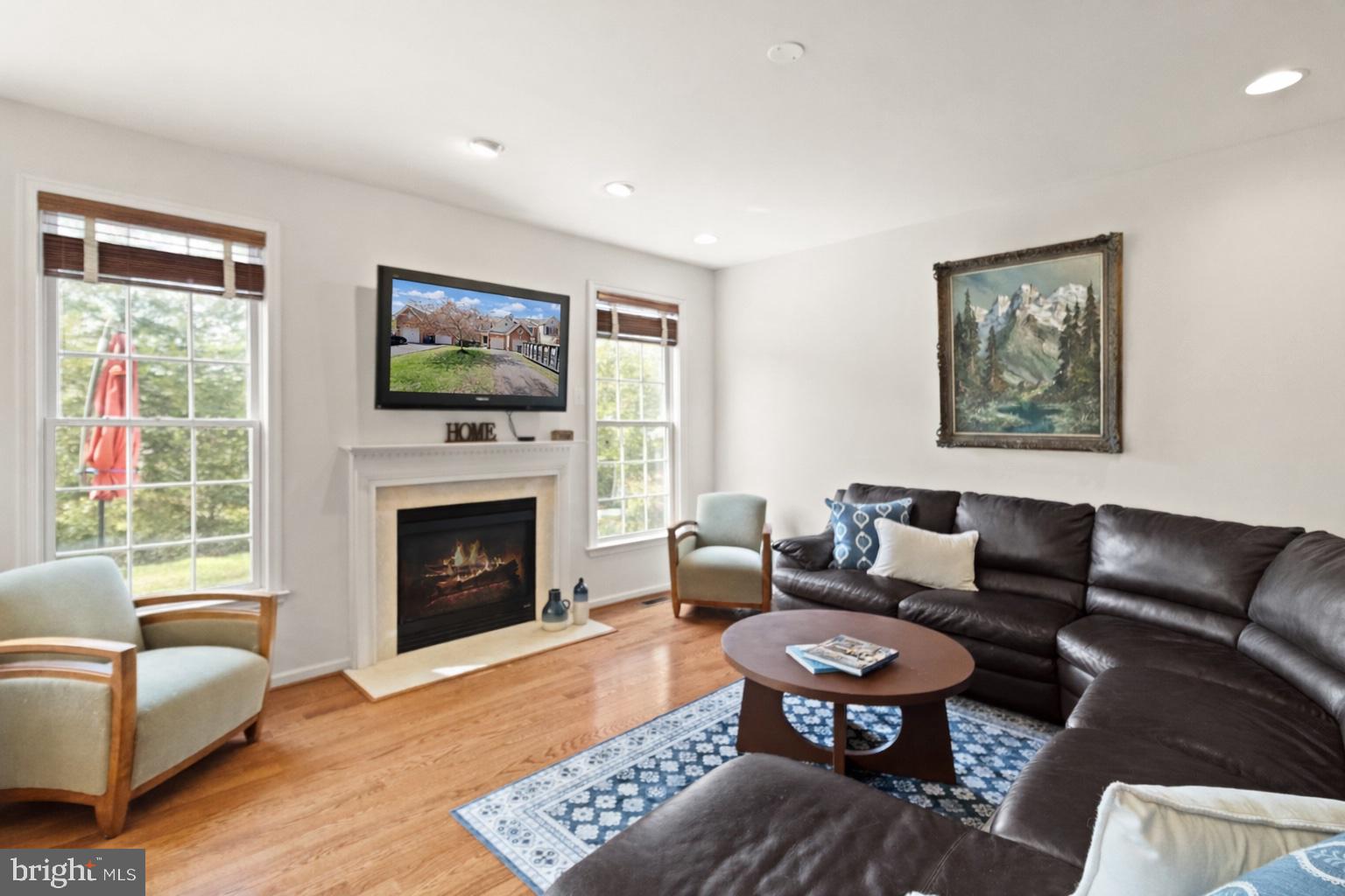 5652 Wheelwright Way Haymarket, VA 20169 - Photo 7 of 32 a living room with furniture a flat screen tv and a fireplace