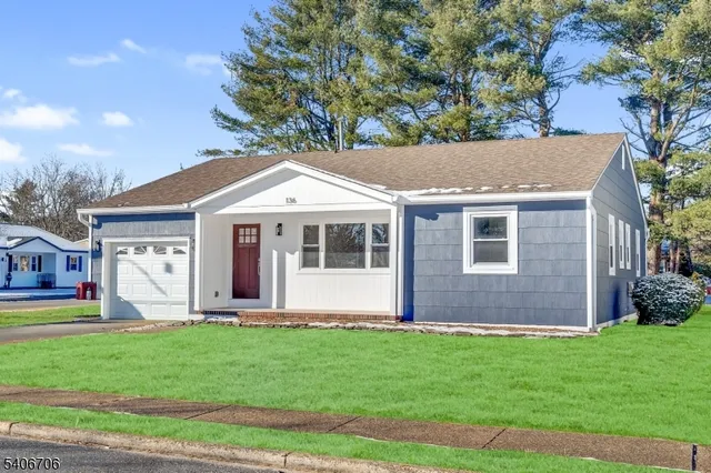a front view of a house with a garden and yard