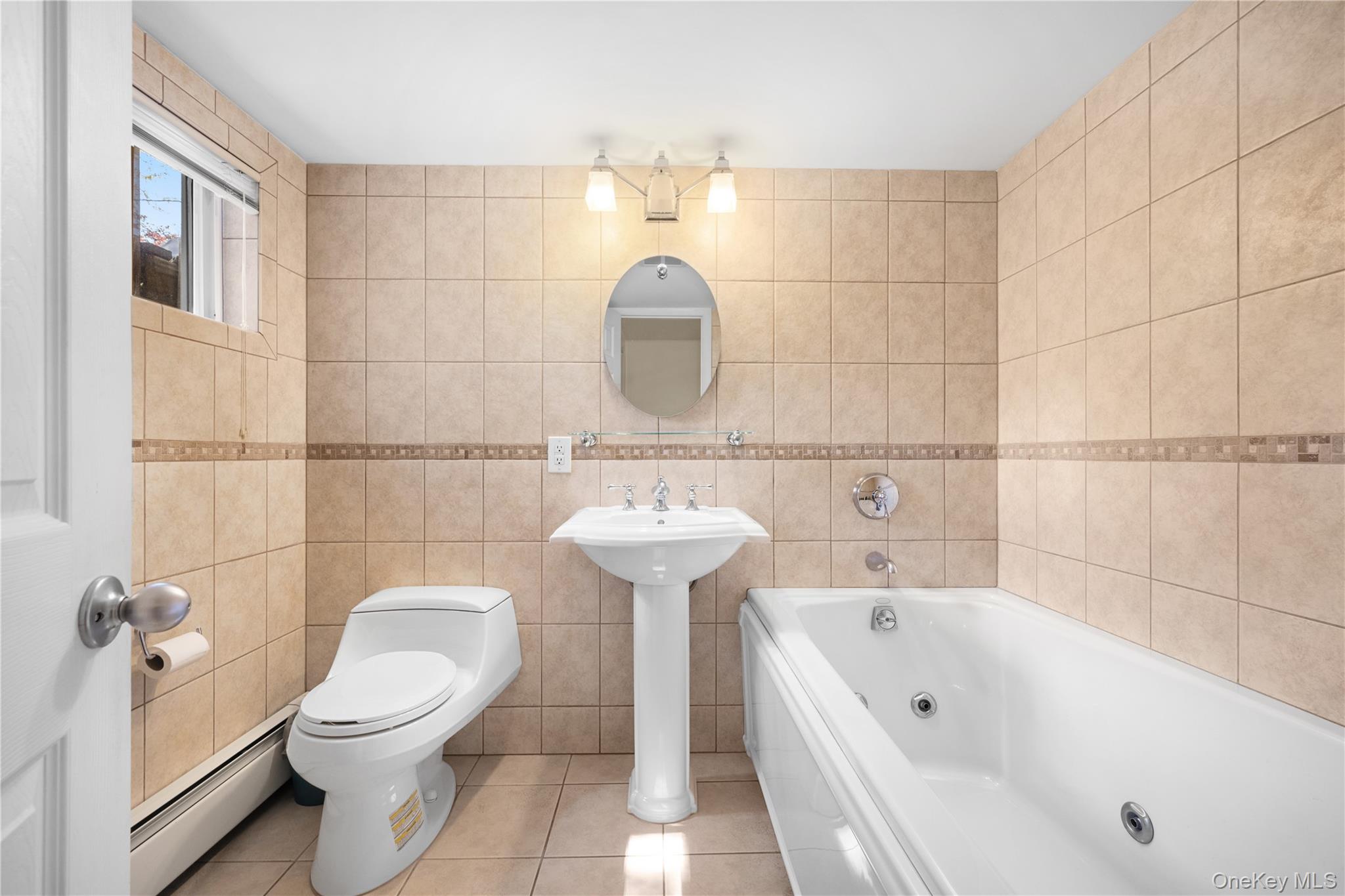 150 Roxton Road Plainview, NY 11803 - Photo 18 of 25 a bathroom with a sink a toilet and shower