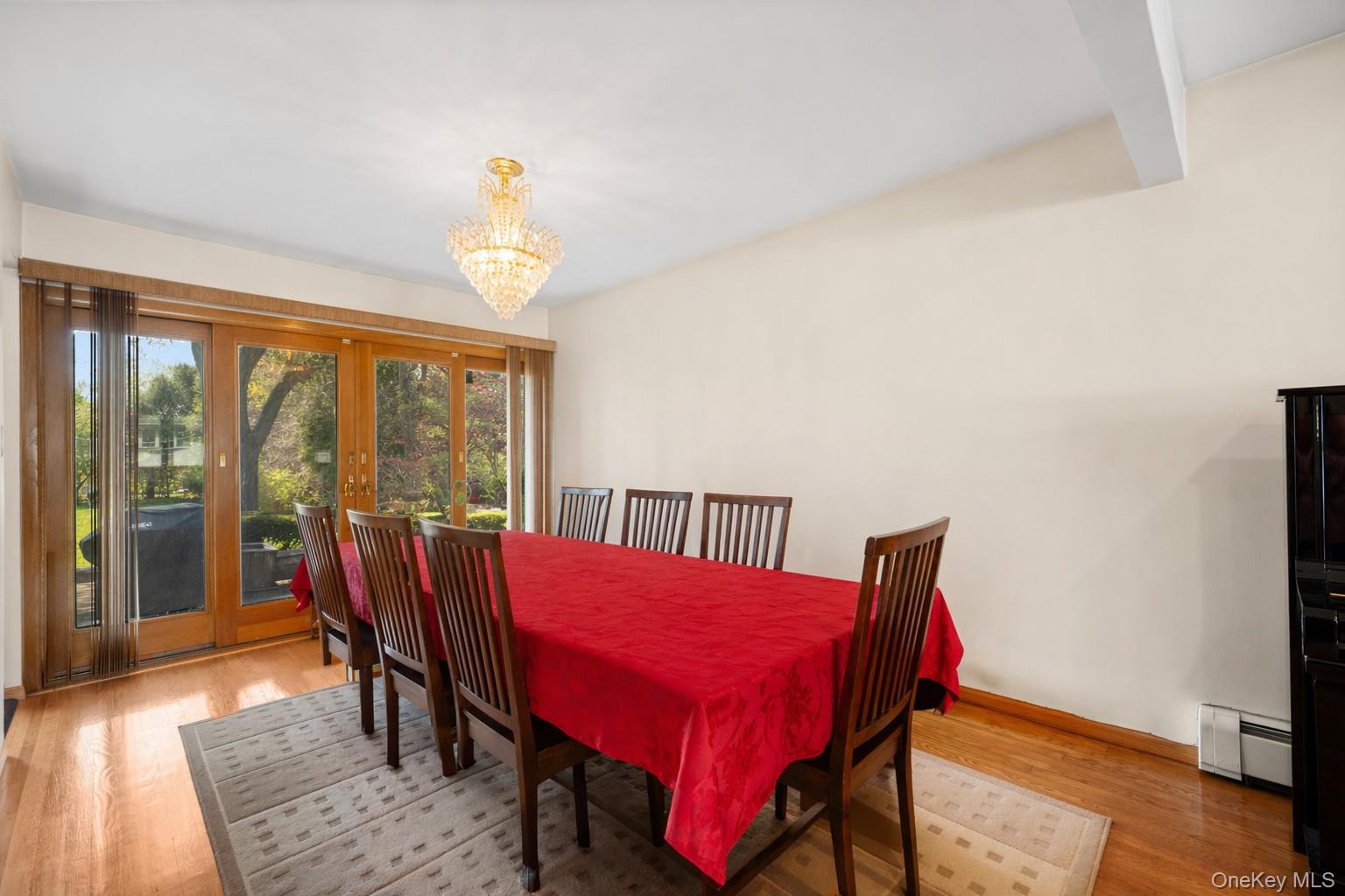 150 Roxton Road Plainview, NY 11803 - Photo 6 of 25 a view of a dining room with furniture a chandelier and wooden floor