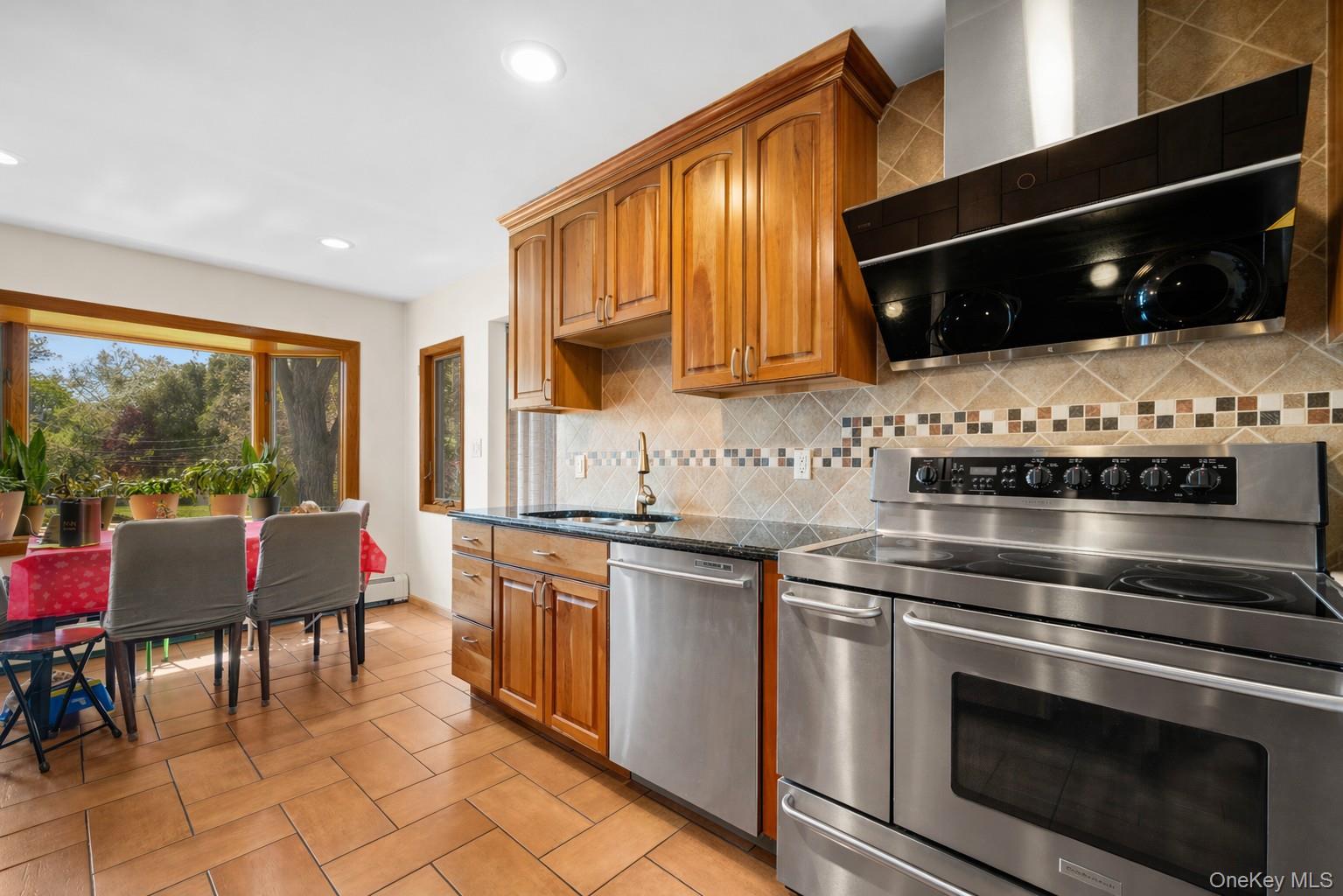 150 Roxton Road Plainview, NY 11803 - Photo 8 of 25 a kitchen with stainless steel appliances a stove a sink and a microwave