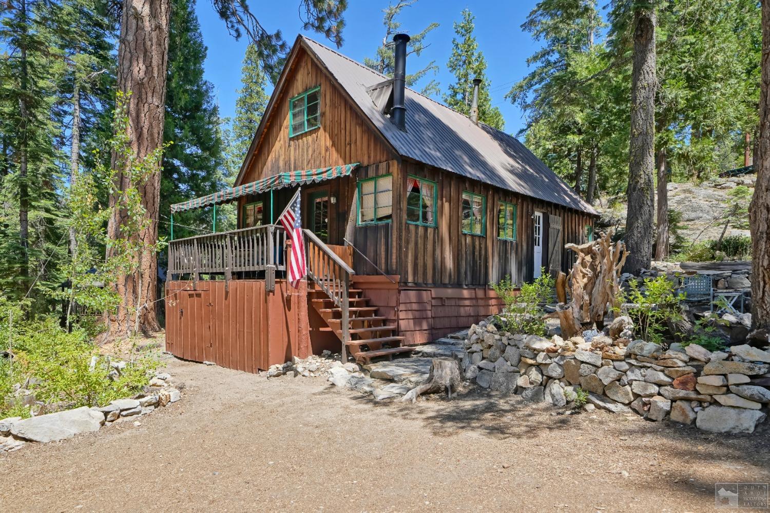 a view of a house with a small yard and wooden fence