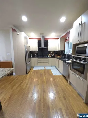 a kitchen with stainless steel appliances granite countertop a sink a stove and a refrigerator