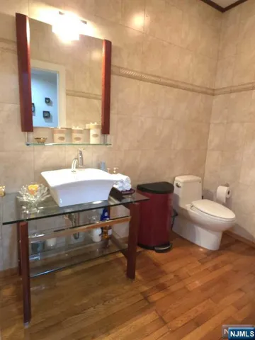 a bathroom with a sink a toilet and mirror