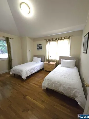 a bedroom with two beds and a large window