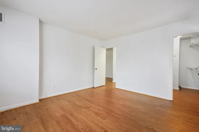 a view of an empty room with wooden floor