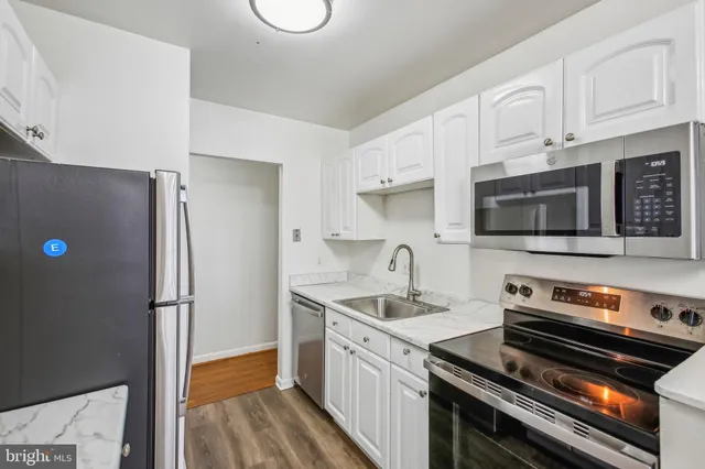a kitchen with stainless steel appliances a stove microwave and sink