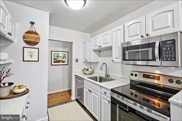 a kitchen with stainless steel appliances a stove a sink and a microwave