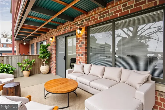 a view of a patio with couches table and chairs and potted plants