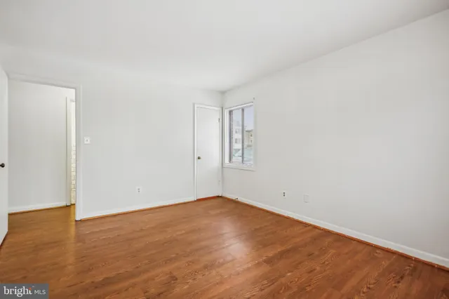 an empty room with wooden floor and white walls
