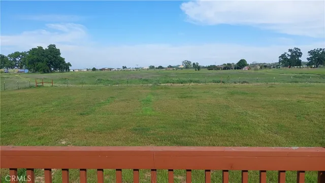 a view of a house with a backyard and wooden fence