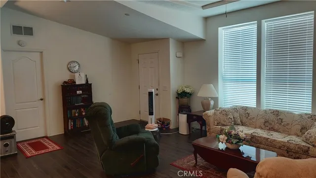 a kitchen with stainless steel appliances granite countertop a dining table chairs refrigerator and microwave