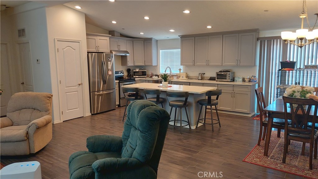 4250 Osborn Road Flournoy, CA 96021 - Photo 32 of 68 a kitchen with stainless steel appliances granite countertop a refrigerator a stove a sink a dining table and chairs with wooden floor
